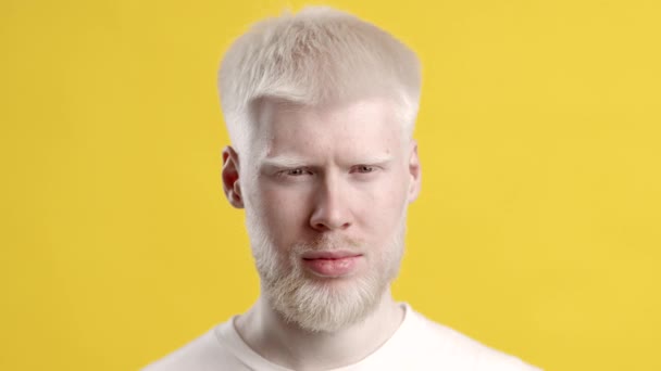 Allvarlig Albino Man tittar på kameran på gul bakgrund — Stockvideo