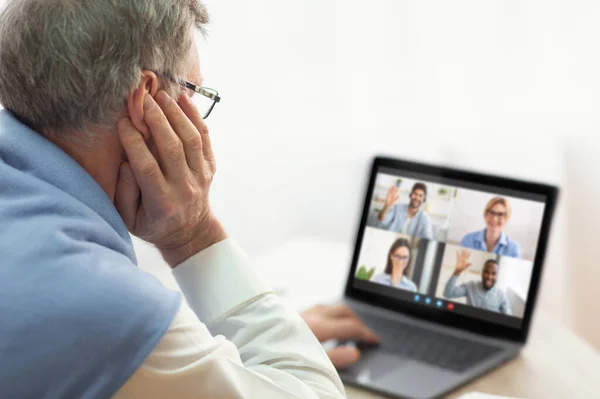 Idősebb férfi csoportos videokonferenciát tart otthon nears vagy munkatársaival — Stock Fotó