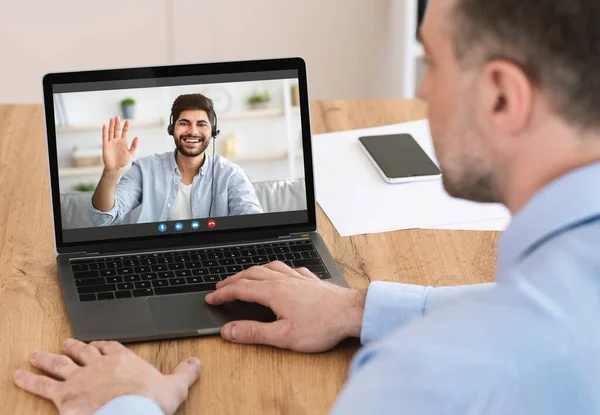 Joven irreconocible que tiene videollamada con su amigo o colega en línea, utilizando el ordenador portátil en casa — Foto de Stock