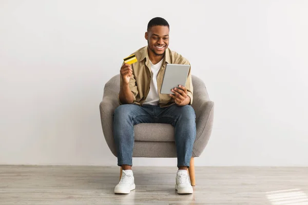 Homem usando Tablet e cartão de crédito Compras on-line, fundo cinza — Fotografia de Stock