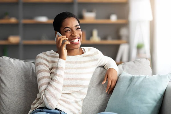 Retrato de alegre afro-americano feminino falando no telefone móvel em casa — Fotografia de Stock