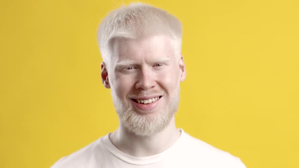 Ritratto di felice albino ragazzo in posa su giallo studio sfondo — Video Stock