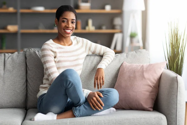 Domácí zábava. Veselý mladý afroameričan žena relaxační v obývacím pokoji — Stock fotografie