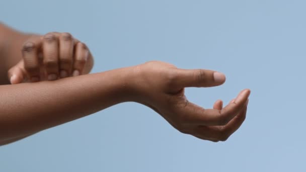 Femmina africana che soffre di eczema grattandosi le mani formicolanti, sfondo blu — Video Stock