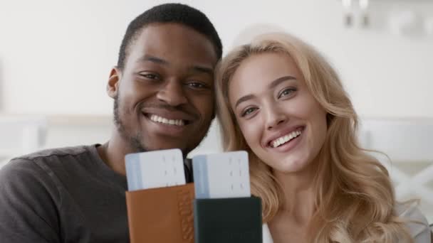 Щаслива багатоетнічна пара, що показує квитки подорожі та паспорти, що позують індори — стокове відео