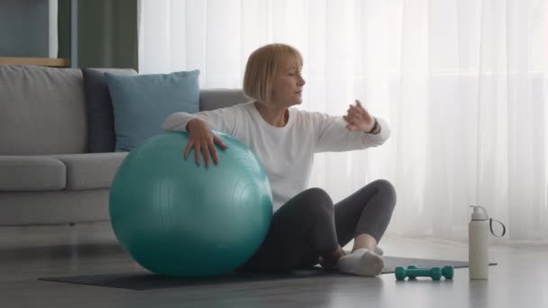 Senior Kvinna Med Fitness Tracker Efter Träning Med Fitball Inomhus — Stockvideo