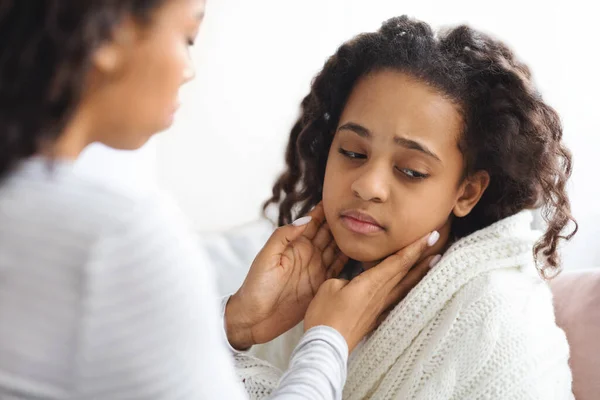 非裔美国母亲揉搓她生病的女儿脖子 — 图库照片