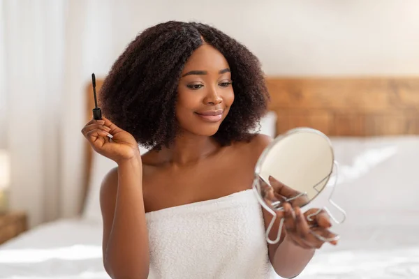 Portrait de beauté de femme noire joyeuse appliquant mascara devant le miroir dans la chambre — Photo