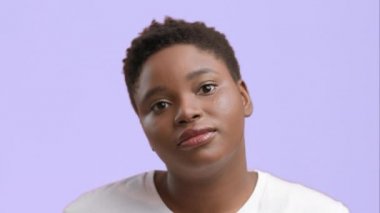 Hiçbir şeyden haberi olmayan Afrikalı Amerikalı Kadın Poz veren Omuzlar, Mor Arkaplan