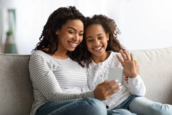Lachende zwarte moeder en dochter met video-oproep op de smartphone — Stockfoto
