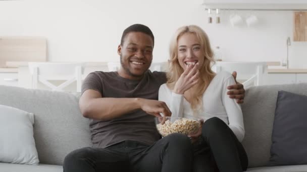 Pari katsomassa televisiota yhdessä syöminen Popcorn ottaa hauskaa kotona — kuvapankkivideo