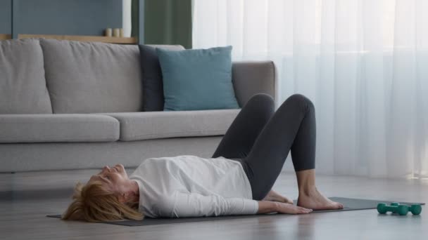 Senior senhora fazendo Yoga Bridge Pose Exercício em casa — Vídeo de Stock