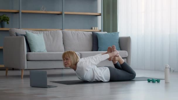 Senior kvinna gör Stretching Motion liggande på mage hemma — Stockvideo