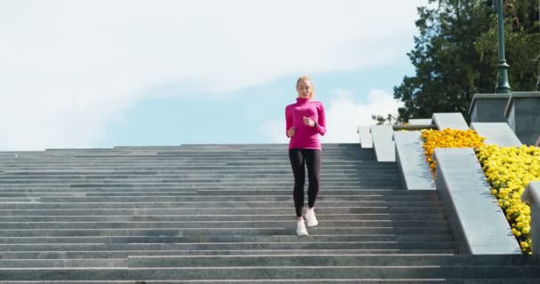 Cardio-training intensif. Jeune femme active courant sur un grand escalier dans un parc urbain, descendant seul les escaliers — Video