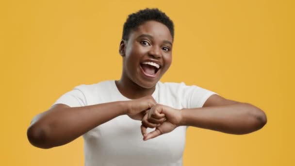 Радостная афроамериканка танцует на желтом фоне — стоковое видео