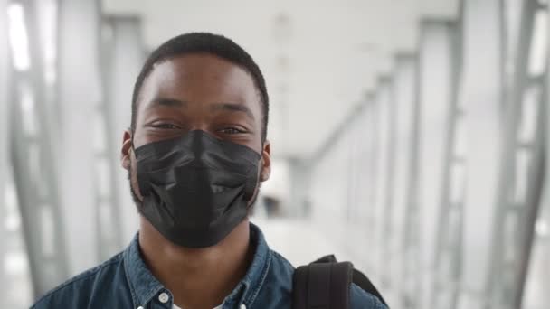 Afro-Amerikaanse reiziger draagt gezichtsmasker staande in de luchthaven — Stockvideo