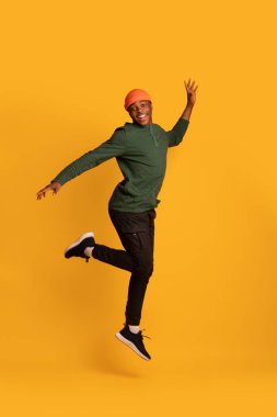 Neşeli Heyecanlı Siyah Hippi Adam Sarı Arkaplanda Atlıyor