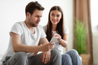 Kıskanç eş aldatan kocayı yatak odasında telefonunu gösterirken yakaladı.