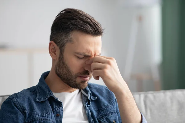 Hombre barbudo con dolor de cabeza, tocándose el puente nasal — Foto de Stock