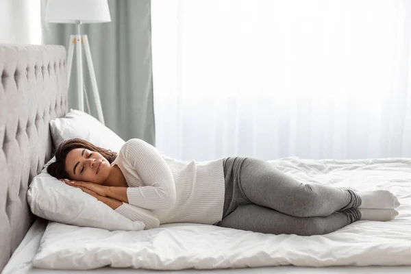 침대에서 자고 있는 젊은 흑인 여성의 모습 — 스톡 사진