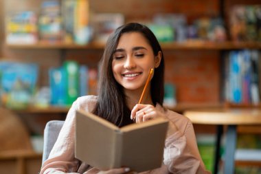 Mutlu Laitin kadını gelecek planları düşünüyor, kafeteryada otururken not defterine yazılacak listeler.