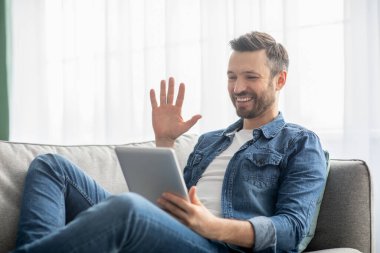 Mutlu orta yaşlı bir adam bloknotla video konferansı yapıyor.