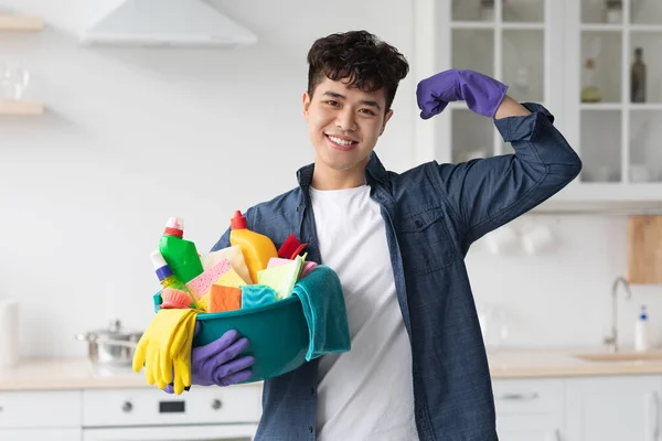 Positivo asiatico ragazzo con pulizia forniture mostrando muscoli — Foto Stock