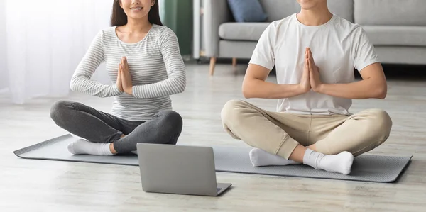 Обрізана азіатська пара практикує йогу вдома — стокове фото