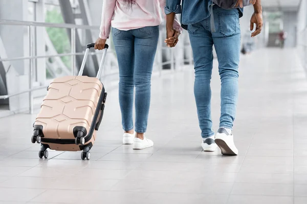 Transporte aéreo. Imagen recortada de pareja negra caminando con equipaje en el aeropuerto — Foto de Stock