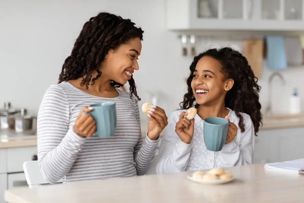Χαριτωμένο μαύρο μητέρα και η κόρη πίνοντας τσάι με μπισκότα — Φωτογραφία Αρχείου