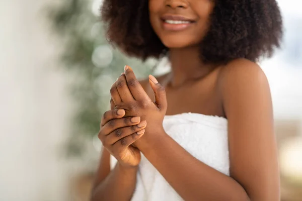 Cropped view of young black lady applying hand cream after shower or bath, enjoying domestic skincare procedure — Stock Photo, Image