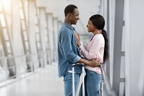 Älskade afroamerikanska mannen och kvinnan gosande i flygplatsterminalen före flygningen — Stockfoto