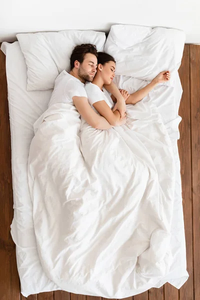 Vista superior de la pareja casada durmiendo juntos abrazando el descanso en el dormitorio —  Fotos de Stock