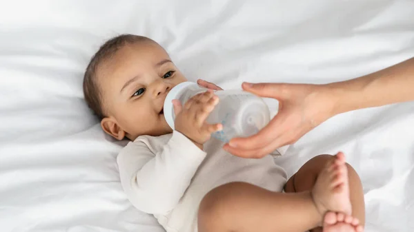 Küçük Afrikalı Amerikalı çocuk bebek şişesinden içiyor. — Stok fotoğraf