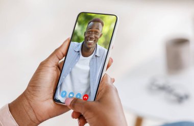 Video çağrısı. Siyah kadın, erkek arkadaşıyla internette buluşmak için akıllı telefon kullanıyor.