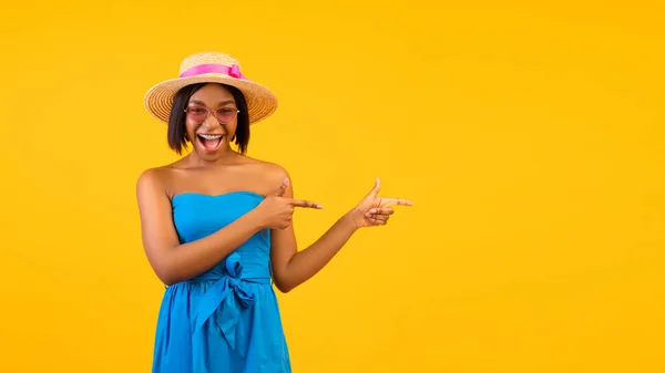 Lovely African American woman shouting WOW in excitement, pointing aside at free space on orange studio background — Stock Photo, Image