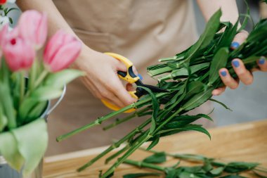 Çiçek atölyesinde çalışan çiçekçi, çiçek buketi üretiyor ve iş yerindeki kilitlenmeden sonra güvende oluyor.