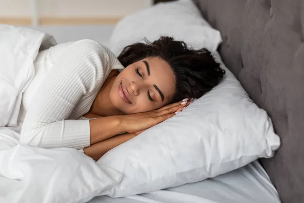 Portrait of young African American woman sleeping in bed