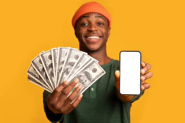 Vitória online. Alegre Africano Guy Demonstrando Dolar Dinheiro e Smartphone em branco — Fotografia de Stock