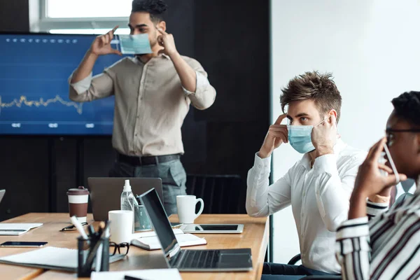 Personas internacionales que usan máscaras médicas en el trabajo — Foto de Stock