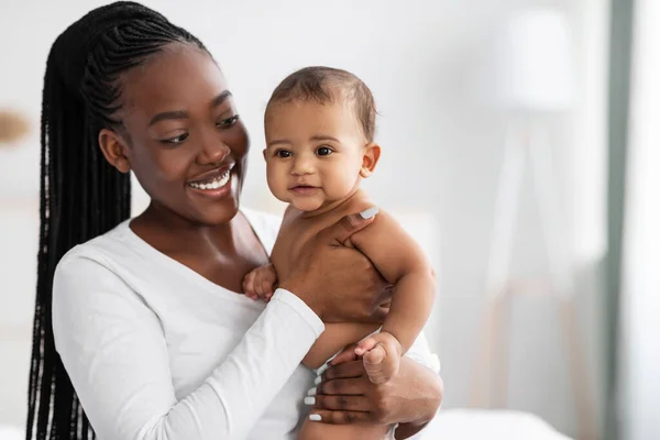 Afrikansk amerikansk barnflicka kramar sitt söta spädbarn och poserar — Stockfoto