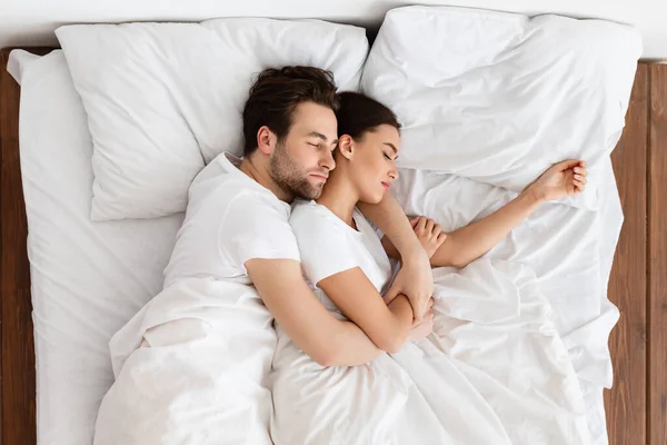 Σύζυγος και σύζυγος αγκαλιάζουν τον ύπνο μαζί στο κρεβάτι εσωτερικό, πάνω από την άποψη — Φωτογραφία Αρχείου