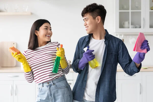Весела азіатська пара позує під час прибирання кухні — стокове фото