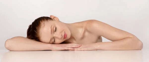Shirtless Ingwerhaarige junge Frau schläft posiert über weißem Hintergrund — Stockfoto