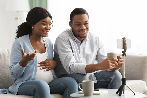 Веселая черная пара блоггеров вещание из дома, беременность концепции блога — стоковое фото