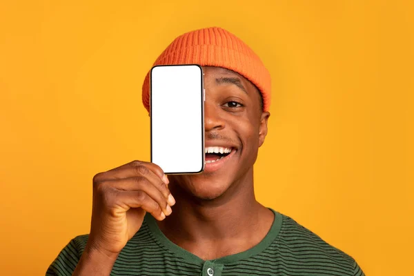 Cheerful Black Hipster Guy Covering Face With Smartphone With Blank White Screen — Stock Photo, Image