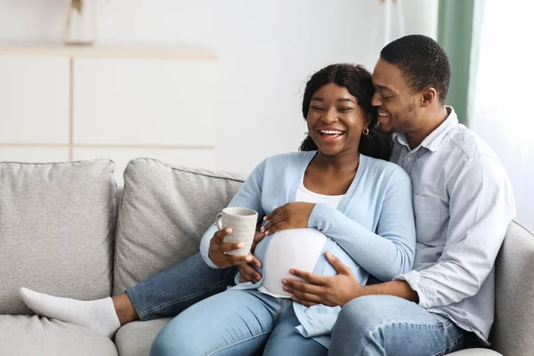 Liefhebbende echtgenoot zoenen zijn lachende zwangere vrouw, home interieur — Stockfoto