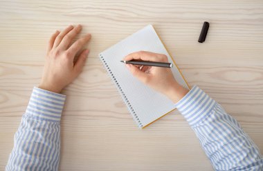 Yaratıcılık ve ilham konsepti. Kadın el yazısı planı boş defterde, elinde siyah kalem var.