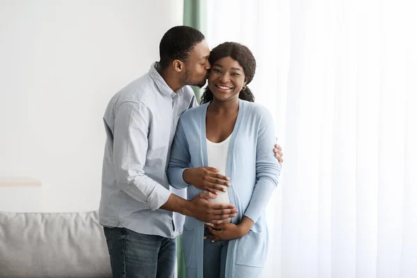 Любящий муж целует свою беременную жену — стоковое фото
