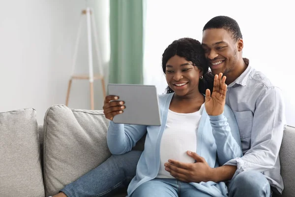 즐겁게 임신 한 흑인 남녀 디지털 태블릿을 사용하여 비디오 통화를 하는 모습 — 스톡 사진